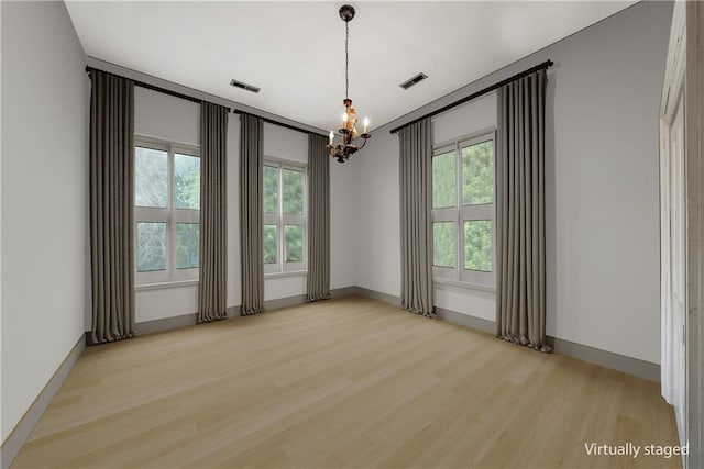 5322 SE Riverside Ter, Saint Joseph, MO 64507 - spare room with a chandelier, wood finished floors, healthy amount of natural light, and baseboards