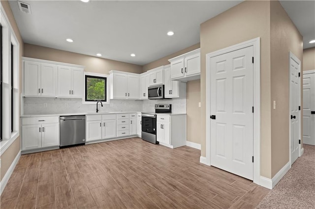 26696 235th St, Mclouth, KS 66054 - kitchen with stainless steel appliances, decorative backsplash, white cabinetry, light countertops, and recessed lighting