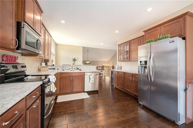 13511 W 56th Ter, Shawnee, KS 66216 - kitchen featuring stainless steel appliances, a peninsula, dark wood-type flooring, tasteful backsplash, and recessed lighting
