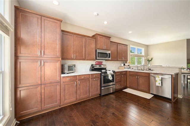 13511 W 56th Ter, Shawnee, KS 66216 - kitchen featuring stainless steel appliances, backsplash, dark wood-type flooring, brown cabinetry, and recessed lighting