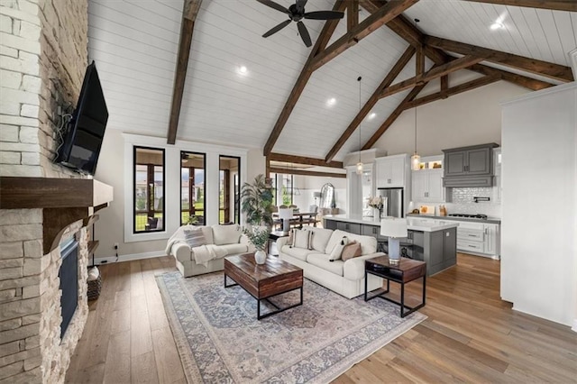 3053 NW Thoreau Ln, Lees Summit, MO 64081 - living area with high vaulted ceiling, ceiling fan, a fireplace, wood-type flooring, and a wood ceiling with exposed beams