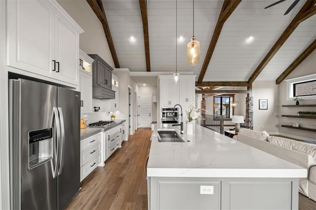 3053 NW Thoreau Ln, Lees Summit, MO 64081 - kitchen featuring stainless steel appliances, wood finished floors, a large island with sink, and white cabinetry