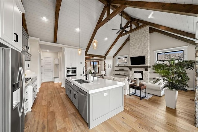 3053 NW Thoreau Ln, Lees Summit, MO 64081 - kitchen with appliances with stainless steel finishes, a stone fireplace, light countertops, open floor plan, and high vaulted ceiling
