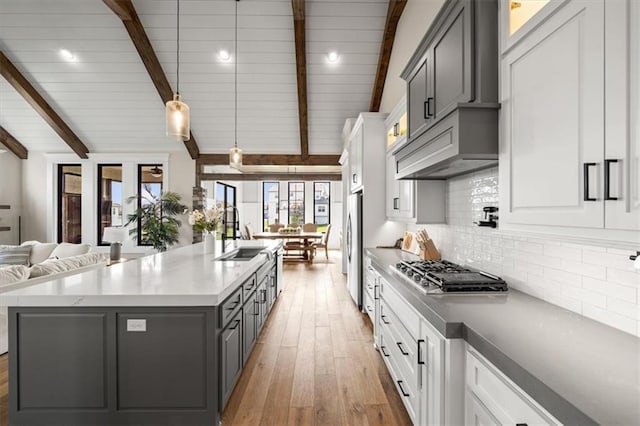 3053 NW Thoreau Ln, Lees Summit, MO 64081 - kitchen featuring stainless steel appliances, light wood finished floors, open floor plan, backsplash, and gray cabinets