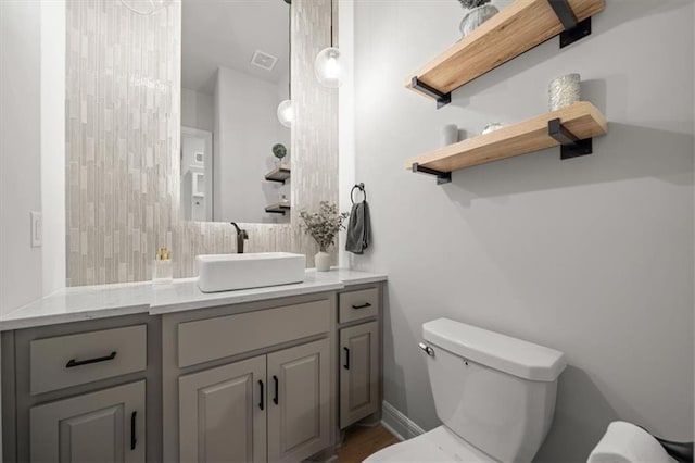 3053 NW Thoreau Ln, Lees Summit, MO 64081 - bathroom with vanity, backsplash, and wood finished floors