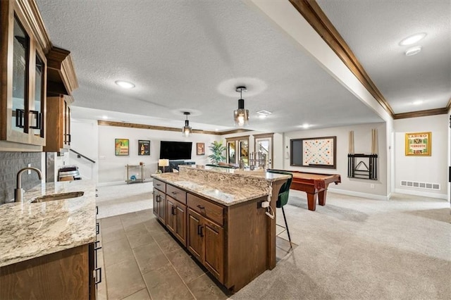 3053 NW Thoreau Ln, Lees Summit, MO 64081 - kitchen featuring open floor plan, a breakfast bar, ornamental molding, billiards, and glass insert cabinets