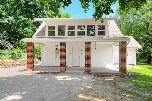 3874 E 63rd St, Kansas City, MO 64130 - view of front of home featuring covered porch and roof with shingles