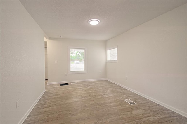 3874 E 63rd St, Kansas City, MO 64130 - empty room with wood finished floors and a textured ceiling
