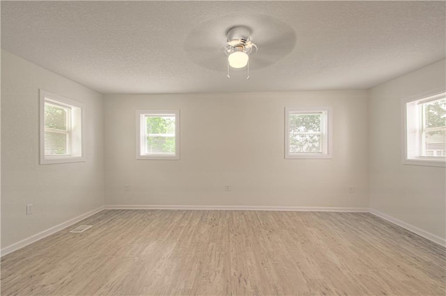3874 E 63rd St, Kansas City, MO 64130 - empty room with light wood-style floors, healthy amount of natural light, a textured ceiling, and ceiling fan