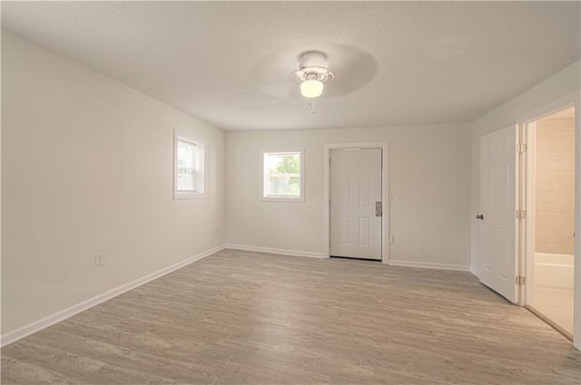 3874 E 63rd St, Kansas City, MO 64130 - spare room with light wood-style flooring, a ceiling fan, and a textured ceiling