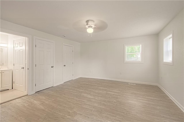 3874 E 63rd St, Kansas City, MO 64130 - unfurnished bedroom featuring light wood finished floors, ensuite bathroom, and ceiling fan