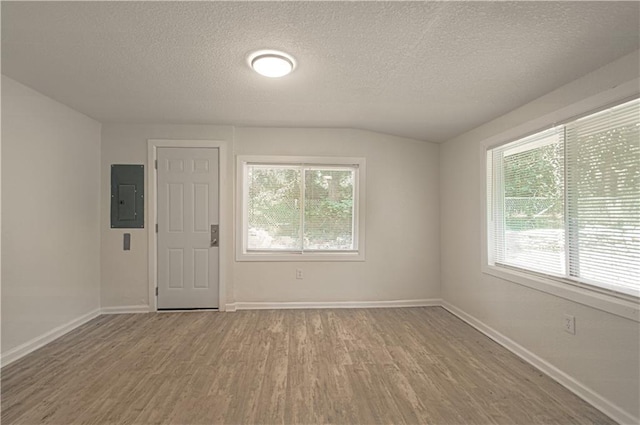 3874 E 63rd St, Kansas City, MO 64130 - unfurnished room featuring electric panel, wood finished floors, a textured ceiling, and lofted ceiling