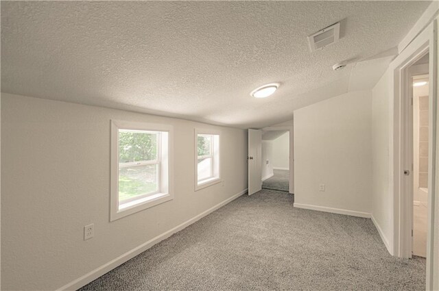3874 E 63rd St, Kansas City, MO 64130 - unfurnished bedroom featuring a textured ceiling, light colored carpet, and vaulted ceiling