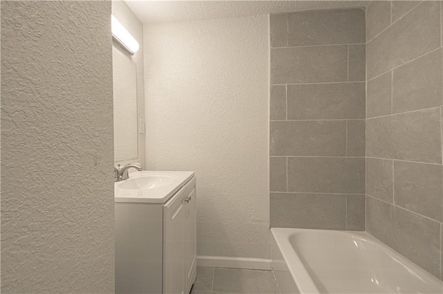 3874 E 63rd St, Kansas City, MO 64130 - full bathroom featuring a textured wall, vanity, and tile patterned floors