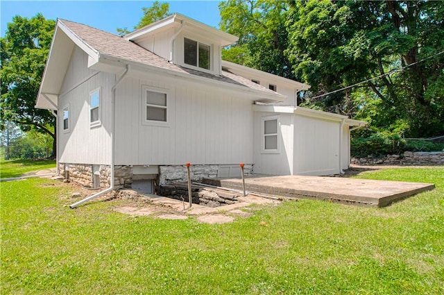3874 E 63rd St, Kansas City, MO 64130 - back of house with a lawn, a shingled roof, and a patio area