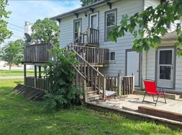 230 E Prairie, Girard, KS 66743 - back of property featuring a wooden deck and a lawn