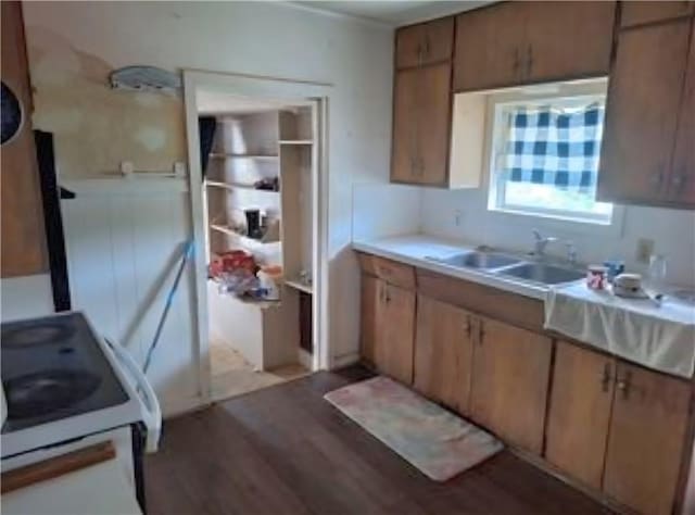 230 E Prairie, Girard, KS 66743 - kitchen with light wood-style flooring, white stove, a sink, light countertops, and brown cabinets