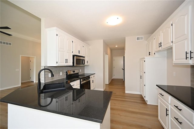 18 Timber Creek Cir, Platte City, MO 64079 - kitchen with appliances with stainless steel finishes, dark countertops, a sink, and a peninsula