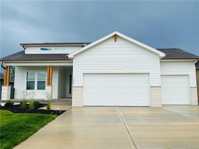 12445 Empress St, Platte City, MO 64079 - view of front of house with an attached garage, concrete driveway, covered porch, and a shingled roof