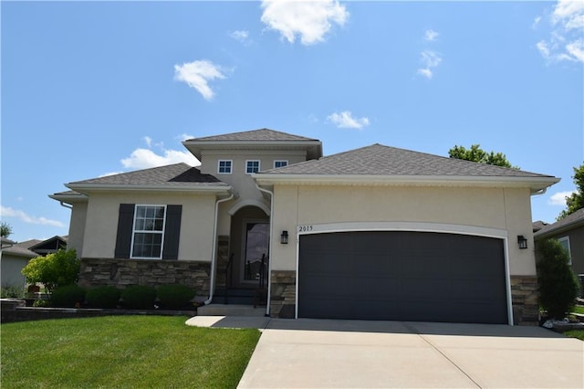 2015 Creek View Ln, Raymore, MO 64083 - prairie-style house featuring stone siding, driveway, stucco siding, an attached garage, and a front lawn