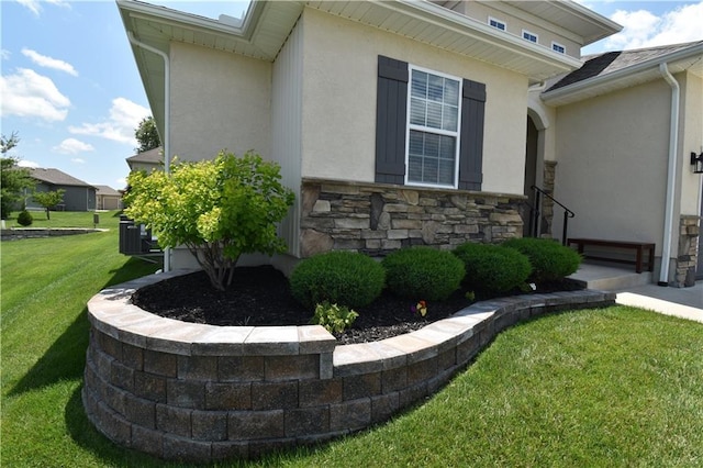 2015 Creek View Ln, Raymore, MO 64083 - view of side of property featuring stucco siding, a lawn, and stone siding