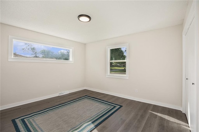 624 S Locust St, Gardner, KS 66030 - unfurnished bedroom featuring dark wood finished floors, multiple windows, and a closet