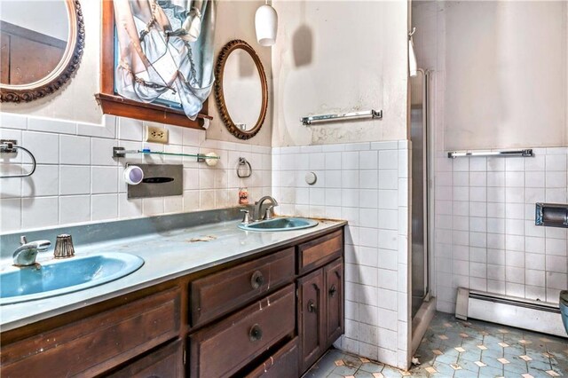 14121 S Haven Rd, Grandview, MO 64030 - full bathroom featuring tile walls, a baseboard heating unit, a shower stall, double vanity, and tile patterned floors