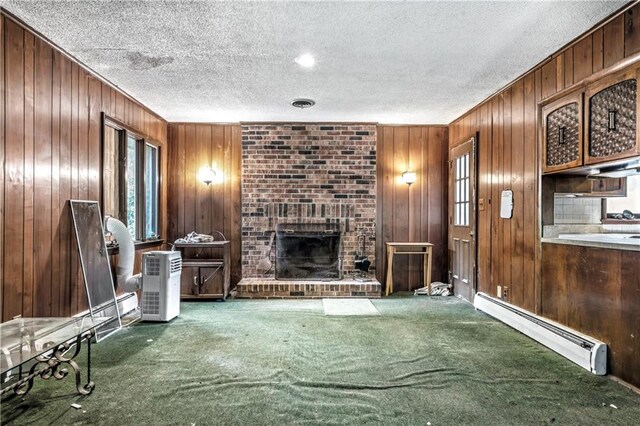 14121 S Haven Rd, Grandview, MO 64030 - unfurnished living room featuring a baseboard radiator, carpet flooring, wooden walls, a textured ceiling, and a brick fireplace