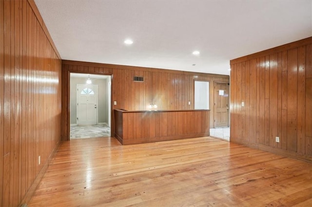 126 W 116th St, Kansas City, MO 64114 - spare room featuring light wood-type flooring and wood walls