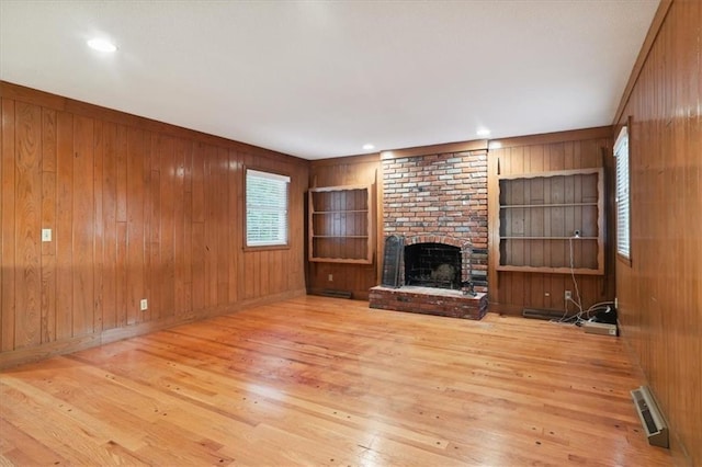126 W 116th St, Kansas City, MO 64114 - unfurnished living room with wood walls, wood-type flooring, built in features, and a fireplace