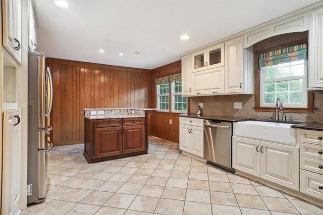 126 W 116th St, Kansas City, MO 64114 - kitchen featuring appliances with stainless steel finishes, wood walls, tasteful backsplash, light tile patterned floors, and recessed lighting