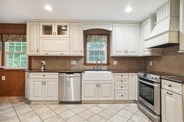 126 W 116th St, Kansas City, MO 64114 - kitchen featuring appliances with stainless steel finishes, premium range hood, light tile patterned floors, decorative backsplash, and recessed lighting