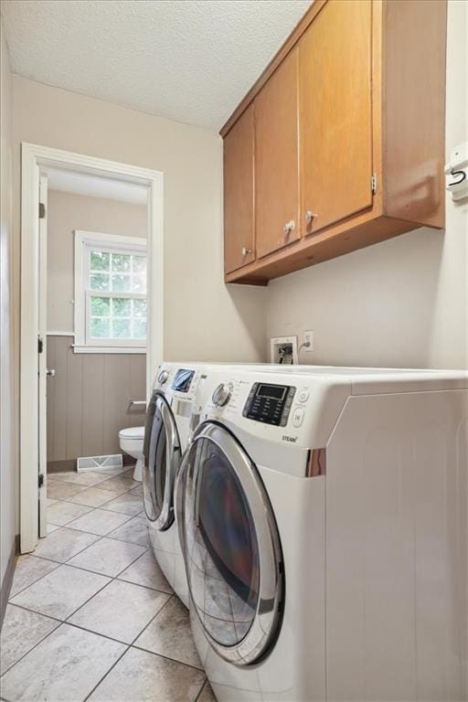 126 W 116th St, Kansas City, MO 64114 - washroom featuring washing machine and clothes dryer, a textured ceiling, light tile patterned floors, and wainscoting
