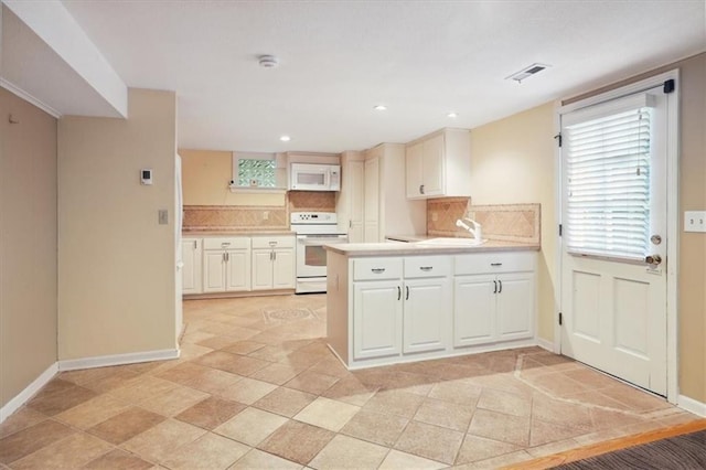 126 W 116th St, Kansas City, MO 64114 - kitchen featuring white appliances, backsplash, a peninsula, light countertops, and recessed lighting