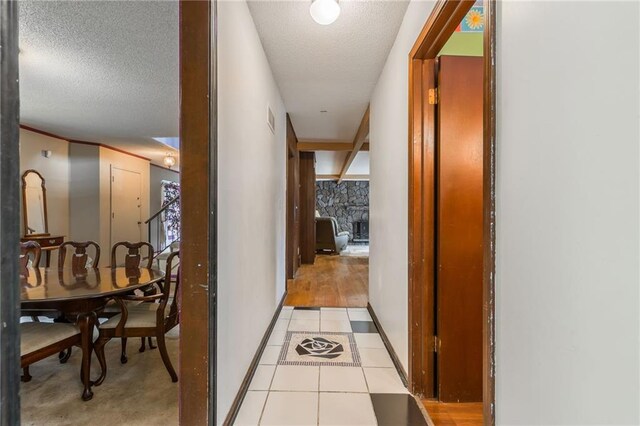9714 Shepherds Dr, Kansas City, MO 64131 - corridor featuring a textured ceiling, light tile patterned floors, and baseboards