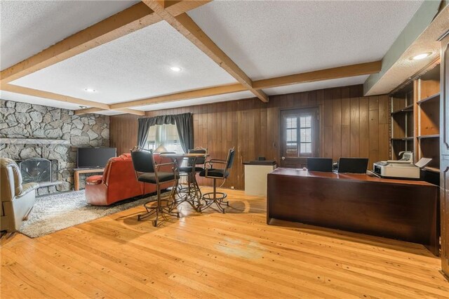 9714 Shepherds Dr, Kansas City, MO 64131 - office with a textured ceiling, beamed ceiling, wood-type flooring, wooden walls, and a fireplace