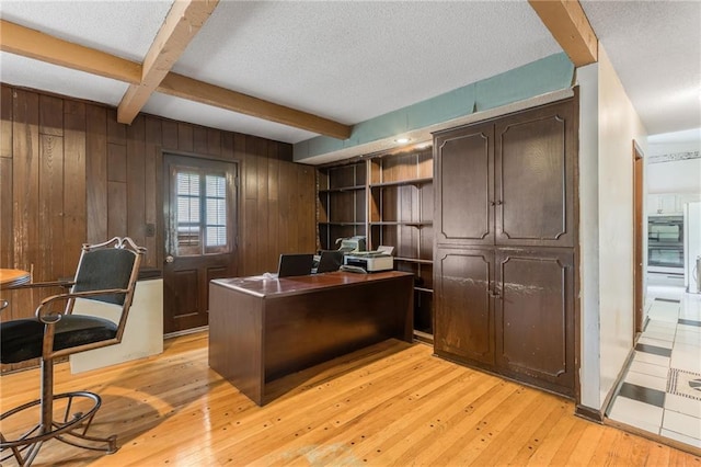 9714 Shepherds Dr, Kansas City, MO 64131 - office featuring beamed ceiling, wooden walls, light wood-style flooring, and a textured ceiling