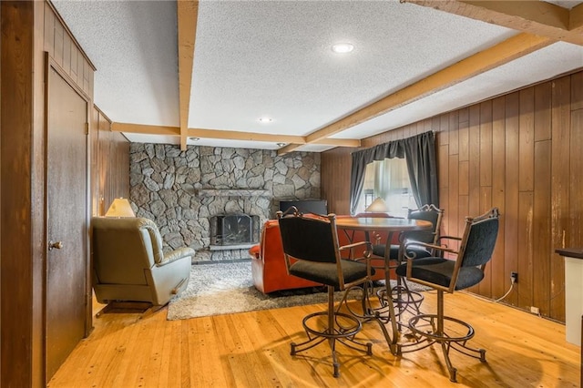 9714 Shepherds Dr, Kansas City, MO 64131 - living area featuring a textured ceiling, beamed ceiling, hardwood / wood-style flooring, wooden walls, and a fireplace