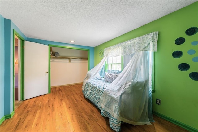 9714 Shepherds Dr, Kansas City, MO 64131 - bedroom with a closet, wood finished floors, and a textured ceiling