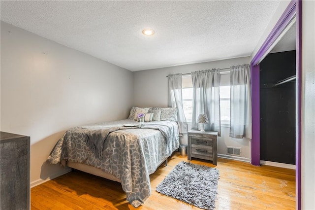 9714 Shepherds Dr, Kansas City, MO 64131 - bedroom with wood finished floors, a textured ceiling, and baseboards