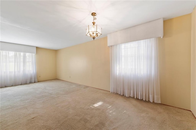 5029 NE 58th St, Kansas City, MO 64119 - carpeted spare room with a chandelier