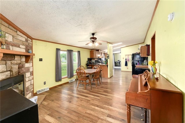 46005 E State Route N, Creighton, MO 64739 - dining area with ornamental molding, a textured ceiling, a ceiling fan, wood finished floors, and a fireplace