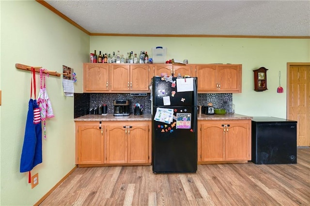 46005 E State Route N, Creighton, MO 64739 - kitchen with freestanding refrigerator, light wood-type flooring, ornamental molding, a textured ceiling, and backsplash
