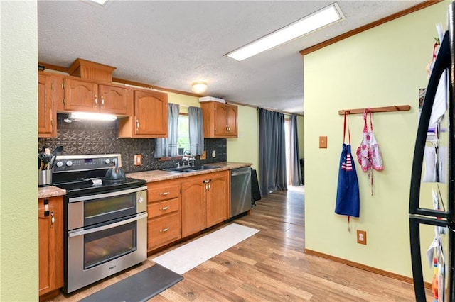 46005 E State Route N, Creighton, MO 64739 - kitchen featuring appliances with stainless steel finishes, a sink, light wood-type flooring, a textured ceiling, and backsplash