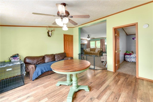 46005 E State Route N, Creighton, MO 64739 - living area with wood finished floors, ornamental molding, a ceiling fan, a textured ceiling, and a fireplace