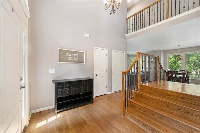 5827 Roundtree St, Shawnee, KS 66226 - staircase featuring a chandelier, wood finished floors, and a high ceiling
