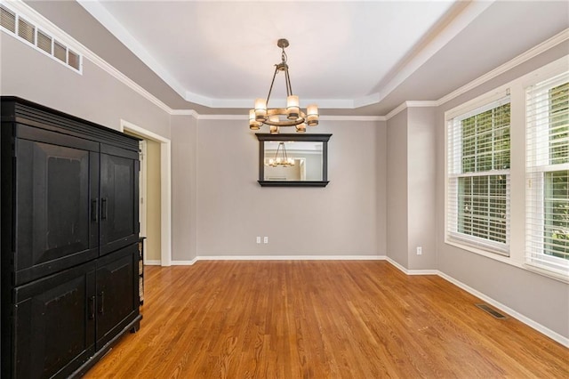 5827 Roundtree St, Shawnee, KS 66226 - empty room with light wood-type flooring, a tray ceiling, healthy amount of natural light, and a chandelier