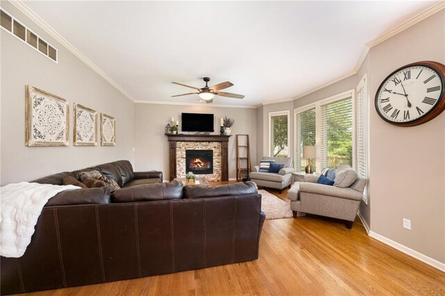 5827 Roundtree St, Shawnee, KS 66226 - living room featuring a ceiling fan, light wood-style floors, ornamental molding, and a fireplace