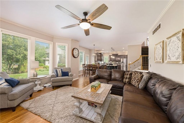 5827 Roundtree St, Shawnee, KS 66226 - living area with ornamental molding, light wood-style flooring, a ceiling fan, and stairs