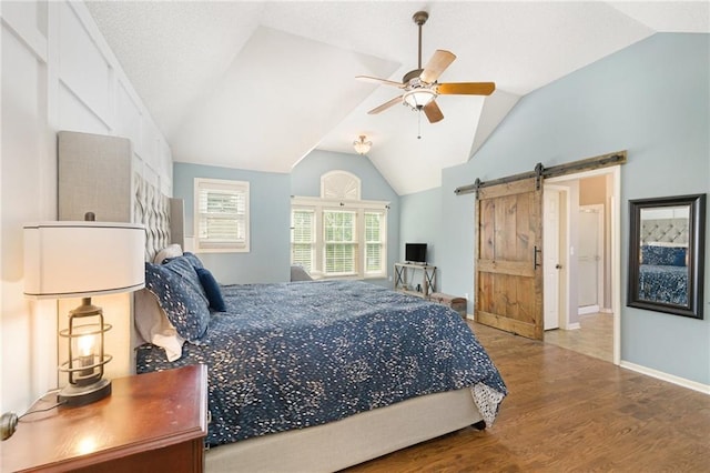 5827 Roundtree St, Shawnee, KS 66226 - bedroom with wood finished floors, vaulted ceiling, a barn door, and ceiling fan